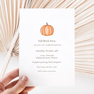 Könnte beinhalten: Eine weiße Einladungskarte mit einer orangefarbenen Aquarell-Kürbis-Illustration oben. Der Text lautet "Fall Block Party" und enthält Veranstaltungsdetails: Datum, Uhrzeit, Ort und RSVP-Informationen. Die Karte wird von einer Hand gehalten.