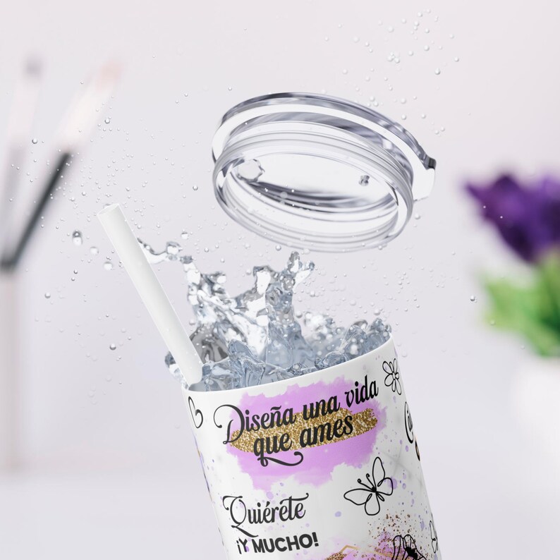 Puede incluir: Tumbler blanco con un dise&ntilde;o rosa y dorado. El tumbler tiene una cita en espa&ntilde;ol que dice "Dise&ntilde;a una vida que ames Qui&eacute;rete y MUCHO!" y presenta una mariposa y otros dise&ntilde;os florales.
