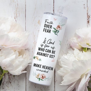 May include: White tumbler with a floral design and the text "Faith Over Fear" and "If God is for us. Who can be against us? Make Heaven crowded".