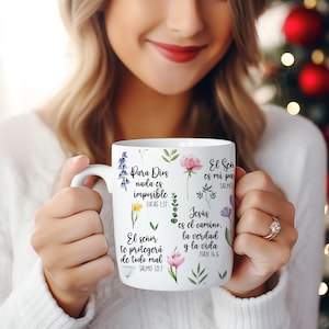 May include: White ceramic mug with a floral design and inspirational quotes in Spanish. The quotes include "Para Dios nada es imposible", "El se&ntilde;or te proteger&aacute; de todo mal", "El Se&ntilde;or es mi pastor", and "Jes&uacute;s es el camino, la verdad y la vida".