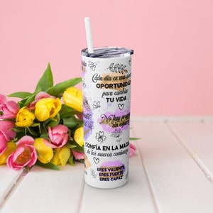 Puede incluir: Tumbler de acero inoxidable blanco con un dise&ntilde;o morado y dorado. El tumbler tiene texto inspirador en espa&ntilde;ol, incluyendo "Cada dia es una oportunidad para cambiar tu vida" y "Confia en la magia de los nuevos comienzos".