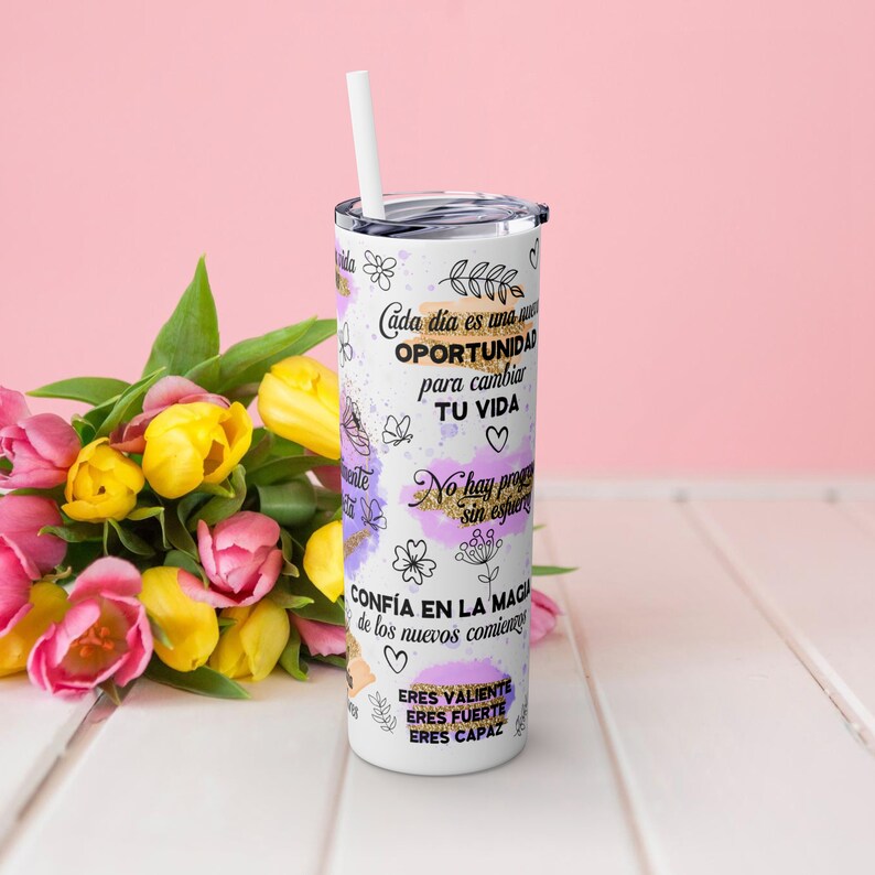 Puede incluir: Tumbler de acero inoxidable blanco con un dise&ntilde;o morado y dorado. El tumbler tiene texto inspirador en espa&ntilde;ol, incluyendo "Cada dia es una oportunidad para cambiar tu vida" y "Confia en la magia de los nuevos comienzos".