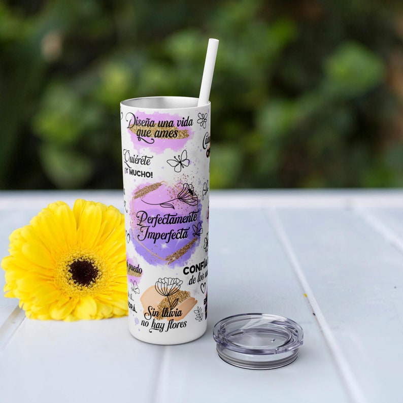 Puede incluir: Un vaso de acero inoxidable blanco con un dise&ntilde;o morado, rosa y dorado. El vaso tiene texto en espa&ntilde;ol inspirador, incluyendo "Dise&ntilde;a una vida que ames" y "Perfectamente Imperfecta".