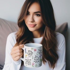 May include: White ceramic mug with floral designs and inspirational bible verses. The mug reads "Nothing is impossible with God", "The Lord is my shepherd", "Jesus is the way, the truth, and the life".