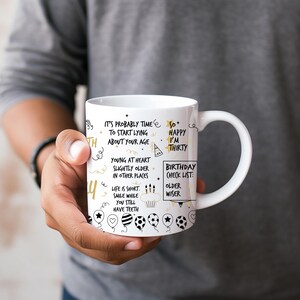 May include: White ceramic mug with a black and gold design. The mug features a birthday message that says "It's probably time to start lying about your age. So happy I'm thirty. Birthday check list: older, wiser."