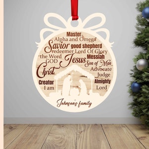 Pu&ograve; includere: Un ornamento natalizio in legno con una silhouette della scena della nativit&agrave; e le parole "Master, Alpha and Omega, Savior good shepherd, redeemer Lord Of Glory, the Word Jesus Messiah, GOD Christ, Creator I am, Son of Man, Advocate, Judge, Almighty Lord, Johnson's family".