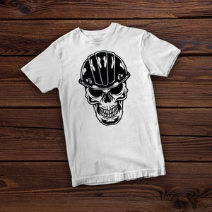 Puede incluir: Camiseta blanca con un gr&aacute;fico en blanco y negro de una calavera con un casco.