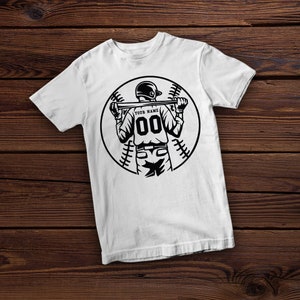 K&ouml;nnte beinhalten: Wei&szlig;es T-Shirt mit einer schwarz-wei&szlig;en Illustration eines Baseballspielers, der einen Schl&auml;ger h&auml;lt. Der Spieler tr&auml;gt eine Baseballuniform mit der Nummer "00" auf dem R&uuml;cken. Der Text "YOUR NAME" befindet sich &uuml;ber der Nummer.