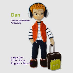 May include: A crochet doll named Dan, 21 inches tall, wearing a white and navy striped shirt, orange vest, navy pants, and brown shoes. The doll has curly orange hair, blue headphones, and carries a brown and lime green suitcase. Text reads: Dan, Crochet Doll Pattern Amigurumi, Large Doll, 21 in / 53 cm, English • Español.
