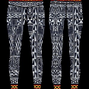 May include: Black leggings with a white geometric pattern. The leggings have a yellow and red band at the waist and ankles.