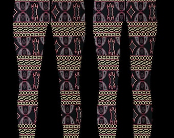 May include: Black leggings with a geometric pattern in gold, pink, and white. The pattern features repeating shapes and lines.
