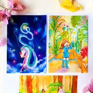 Puede incluir: Tres acuarelas sobre papel blanco. La primera pintura representa un dragón verde sobre un fondo azul con estrellas. La segunda pintura muestra a una niña con un vestido azul de pie en un jardín con flores amarillas. La tercera pintura muestra una criatura rosa con un paraguas de hoja verde en un bosque con un arroyo azul.