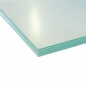 May include: A stack of clear glass sheets with a green edge.
