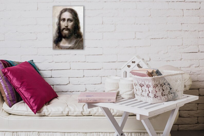 May include: A white couch with pink and purple pillows, a white table with a book and a white lace basket filled with books. The wall behind the couch is white brick.