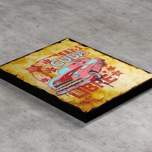 Peut inclure: Impression sur toile de style vintage représentant une voiture classique rouge et bleue avec le mot "CUBA" dans un cercle jaune. L'arrière-plan est un papier jauni et vieilli avec des étoiles et le mot "LIBRE" dans un cercle rouge.