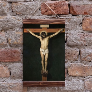 May include: A rectangular wall hanging featuring a reproduction of a crucifixion painting. The artwork depicts a figure on a wooden cross against a dark background, framed by dark wood slats at the top and bottom with a thin hanging string attached.