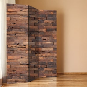 Könnte beinhalten: Ein dreiteiliger Raumteiler mit rustikalem Holzplanken-Design. Die Paneele sind aus braunem Holz mit einer abgenutzten Oberfläche. Der Raumteiler steht auf einem hellen Holzboden.