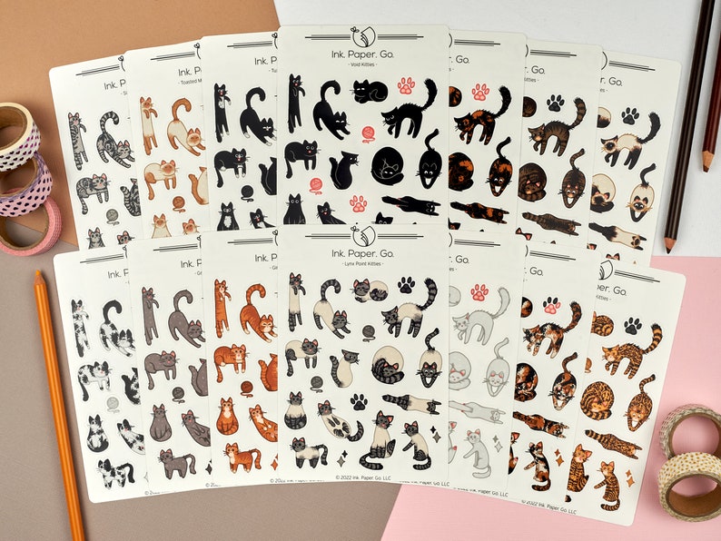 Op de afbeelding: Een set van 10 vellen katten stickers met verschillende poses en kleuren. De stickers zijn gedrukt op wit papier met zwarte contouren en zijn gelabeld met "Ink Paper. Go" en "Ink. F".