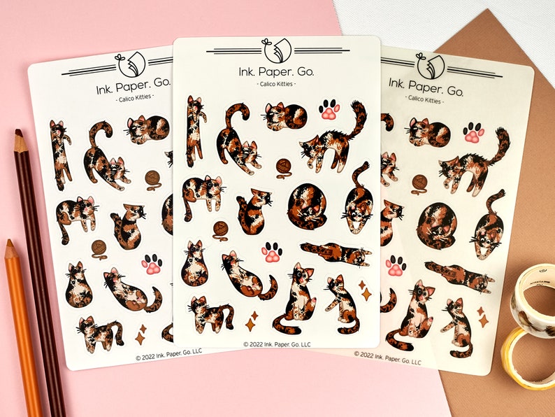 Puede incluir: Tres hojas de pegatinas con gatos calic&oacute; en varias poses. Las pegatinas son blancas con gatos calic&oacute; negros y naranjas. Las pegatinas tienen el texto "Ink. Paper. Go. - Calico Kitties" y "&copy; 2022 Ink Paper Go LLC".