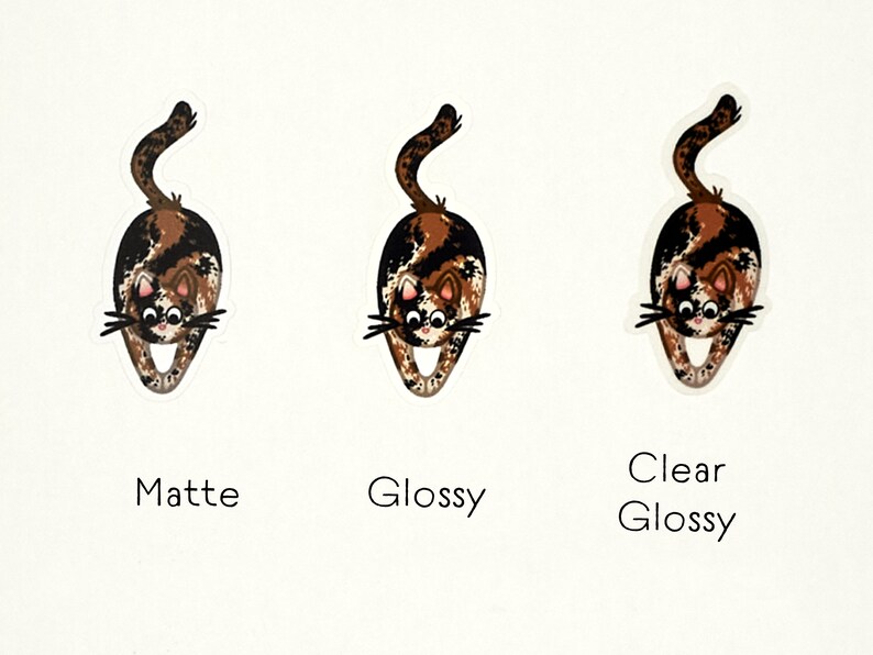 Puede incluir: Tres versiones de una pegatina con un gato calic&oacute; de dibujos animados con pelaje marr&oacute;n, negro y blanco. El gato est&aacute; en una pose juguetona, con la espalda arqueada y la cola levantada. Las pegatinas se muestran sobre un fondo blanco, con las palabras "Mate", "Brillante" y "Brillante transparente" impresas debajo de cada pegatina.