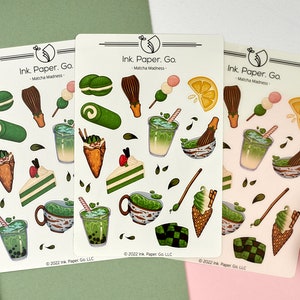 May include: Three sheets of stickers featuring a matcha theme. The stickers are white with green and brown illustrations of matcha drinks, desserts, and other matcha-related items. The text on the stickers reads "Ink. Paper. Go. - Matcha Madness - 2022 Ink Paper Go LLC".