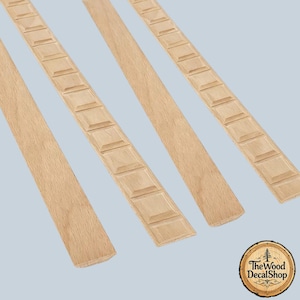 May include: Four long, narrow strips of light-colored natural wood molding. Two strips feature a repeating pattern of raised square blocks, while the other two strips have a smooth, flat surface. A circular logo reads The Wood DecalShop.