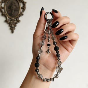 May include: A white ceramic mug with a black handle and the text "But first, coffee" in a black, handwritten-style font. The mug is on a white surface.