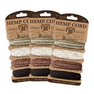 May include: Three spools of hemp cord, each with a different color: natural, brown, and black. The spools are labeled "Hemp Cord" and "Premium Quality" with the company logo and the text "100% Natural Product of the Earth".