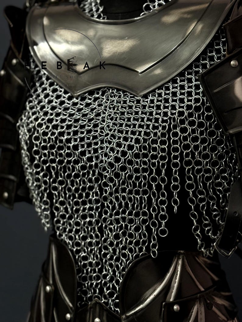 May include: Close-up of medieval armor, featuring a silver chainmail shirt and a polished steel breastplate. The armor has dark leather accents and is designed to protect the torso. The image shows the intricate details of the metalwork.