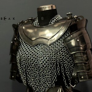 May include: A medieval-style chest armor set, featuring a polished metal breastplate, shoulder guards, and chainmail. The armor is displayed on a black mannequin, with the brand name "HEBEAK" visible in the upper left corner.