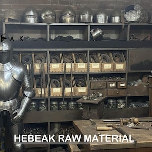 May include: A full suit of silver armor stands in a workshop filled with metal helmets, tools, and materials. The image includes the text "HEBEAK RAW MATERIAL". Shelves hold various items, suggesting a blacksmith or armorer's workspace.