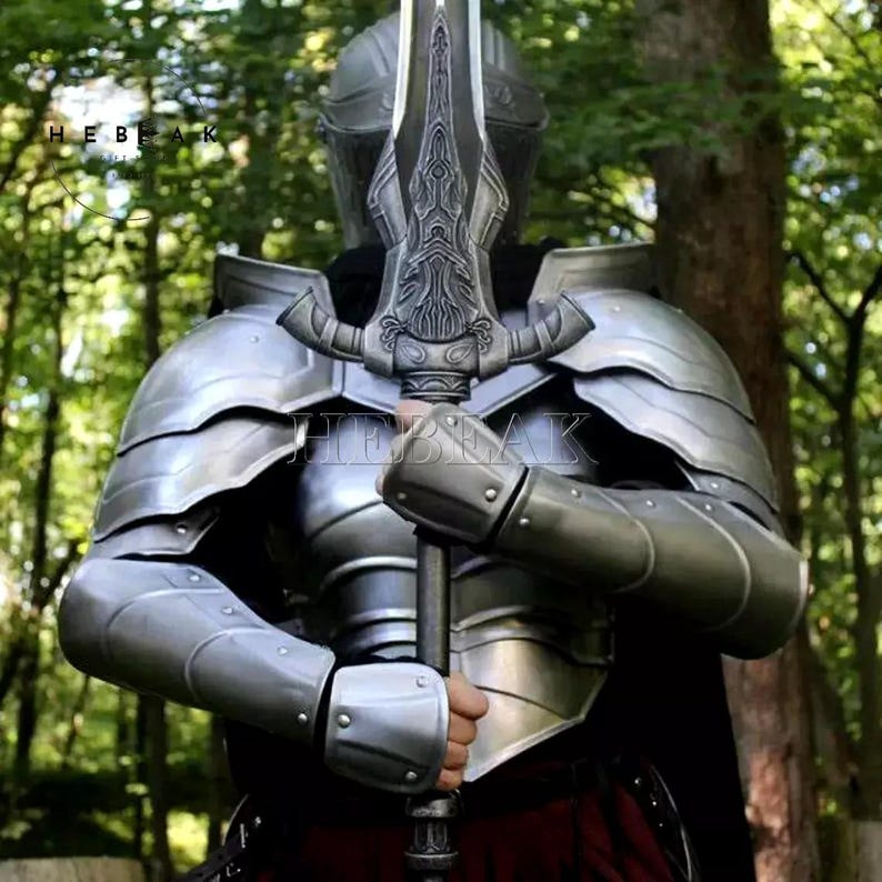 May include: A person wearing silver armor and holding a large, ornate silver sword. The sword has a detailed design and a sharp point. The person is standing in a forest setting.