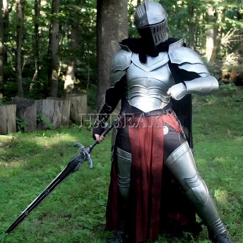May include: A person wearing full plate armor, including a helmet with a visor, and a red and black skirt. They are holding a large, silver sword with a black handle.