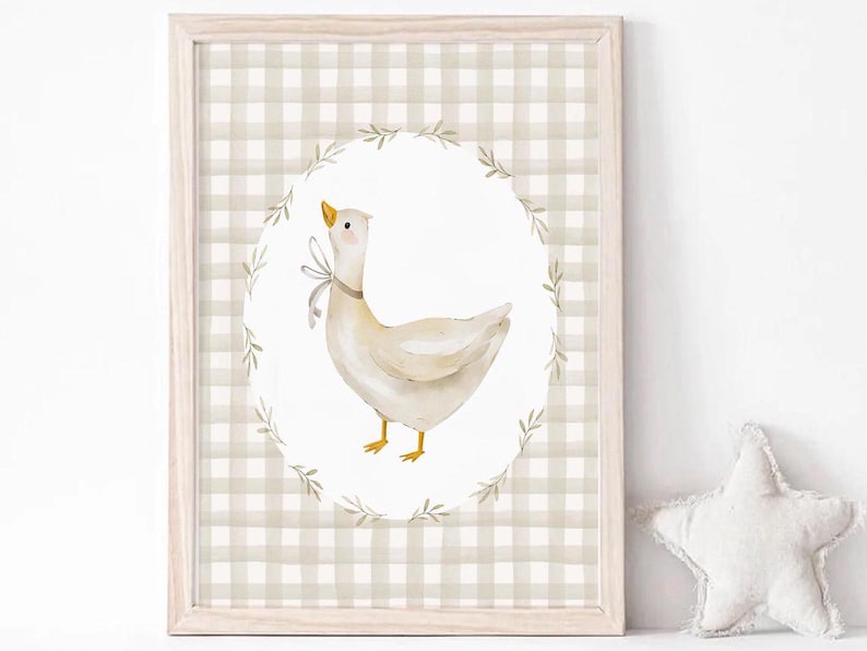 May include: A framed print with a white goose with a brown bow on a white background with a brown and white gingham border.