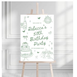 May include: A green and white sign on a wooden easel. The sign reads "Welcome to Rebecca's 50th Birthday Party" with illustrations of champagne, cake, and glasses. The date "1st November 2025" is also included.
