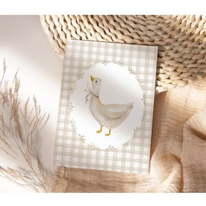 May include: A white goose with a brown and white checkered background. The goose is standing on a green branch with a white oval around it. The background is a light brown color.