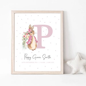 May include: A pink and white personalised baby print with a watercolour illustration of a bunny holding flowers. The print features the letter "P" in pink and the name "Poppy Grace Smith" with the date "20th December 2021" and time "7:35AM".