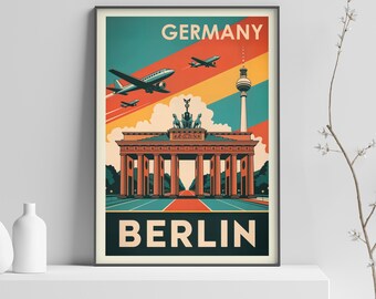 May include: A framed travel poster for Berlin, Germany, featuring a retro design. The poster displays the Brandenburg Gate, a TV tower, and airplanes against a teal, orange, and yellow sky. The word "GERMANY" is at the top, and "BERLIN" at the bottom.