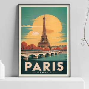 May include: A framed travel poster depicting the Eiffel Tower in Paris, France. The artwork has a vintage aesthetic, with a large yellow sun in the background. The word "PARIS" is displayed in bold letters, with "FRANCE" underneath.