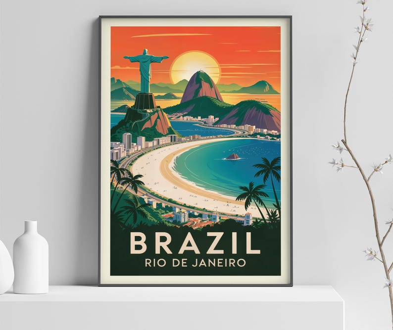 Op de afbeelding: Een ingelijste reisposter van Rio de Janeiro, Brazili&euml;, met het Christus de Verlosser-beeld, de Suikerbroodberg en een zonsondergang boven de kustlijn. De poster heeft de woorden "BRAZIL" en "RIO DE JANEIRO" in witte tekst.