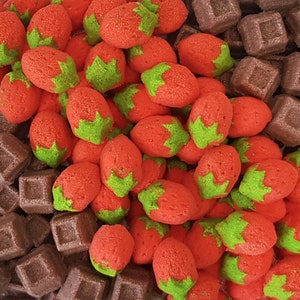 May include: A close-up of strawberry-shaped sweets with green tops and red bodies, alongside square chocolate sweets. The candies are a colourful mix of textures. The image is a top-down view of the sweets.