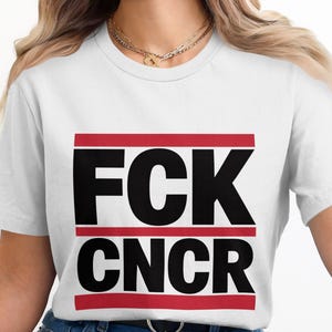 Op de afbeelding: Wit T-shirt met de tekst "FCK CNCR" in zwarte letters, omlijst door rode lijnen. Dit casual kledingstuk is ontworpen voor dagelijks gebruik en is een eenvoudige, gedurfde verklaring.
