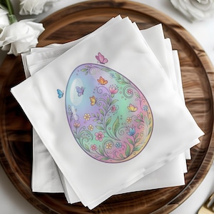 Op de afbeelding: Een stapel witte papieren servetten met een pastelkleurig paasei-ontwerp. Het ei is versierd met bloemen, ranken en vlinders in roze, blauw, geel en groen. De servetten liggen op een houten dienblad.