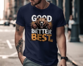 May include: Navy blue t-shirt featuring a brown bear graphic with the words "GOOD BETTER BEST" in white and orange. The bear is centered, with an open mouth and a sunburst design behind it. The shirt is short-sleeved and has a crew neck.