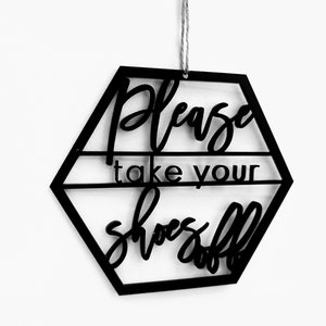 May include: Black hexagonal sign with the text "Please take your shoes off" in a decorative font.