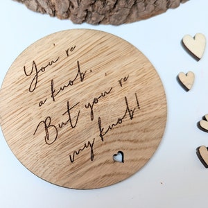 May include: A round wooden coaster with the text "You're a knob, But you're my knob!" engraved on it. There is a small heart cutout in the coaster.