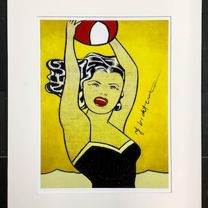 Könnte beinhalten: Pop-Art-Druck einer Frau in einem schwarzen Badeanzug, die einen rot-weißen Strandball über ihrem Kopf hält. Der Hintergrund ist gelb, und die Frau hat schwarzes Haar und rote Lippen. Der Druck ist unten rechts signiert.