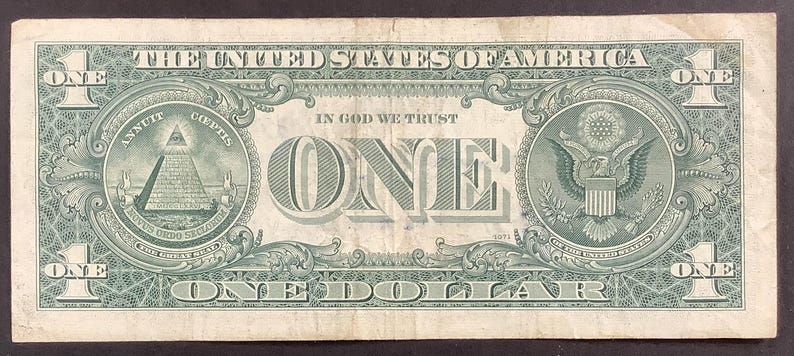 K&ouml;nnte beinhalten: Ein Ein-Dollar-Schein mit gr&uuml;nem und wei&szlig;em Design. Der Text "THE UNITED STATES OF AMERICA" steht oben. Der Schein zeigt die Worte "IN GOD WE TRUST" und "ONE DOLLAR". Die R&uuml;ckseite des Scheins zeigt ein Bild einer Pyramide und eines Adlers.