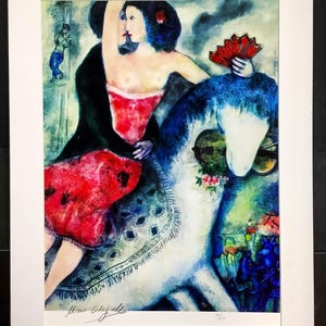 Pode incluir: Impressão emoldurada de uma pintura colorida. Apresenta uma mulher com um vestido vermelho e um xale preto, segurando um leque vermelho, montada em um cavalo branco com detalhes azuis. Um violinista e outras figuras estão no fundo.