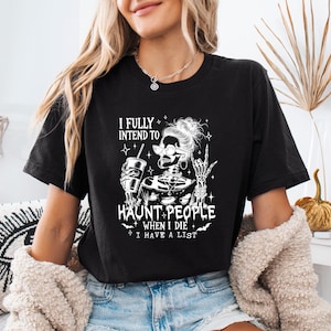 May include: Black t-shirt with a white graphic of a skeleton wearing sunglasses and holding a drink. The text reads "I fully intend to haunt people when I die, I have a list."